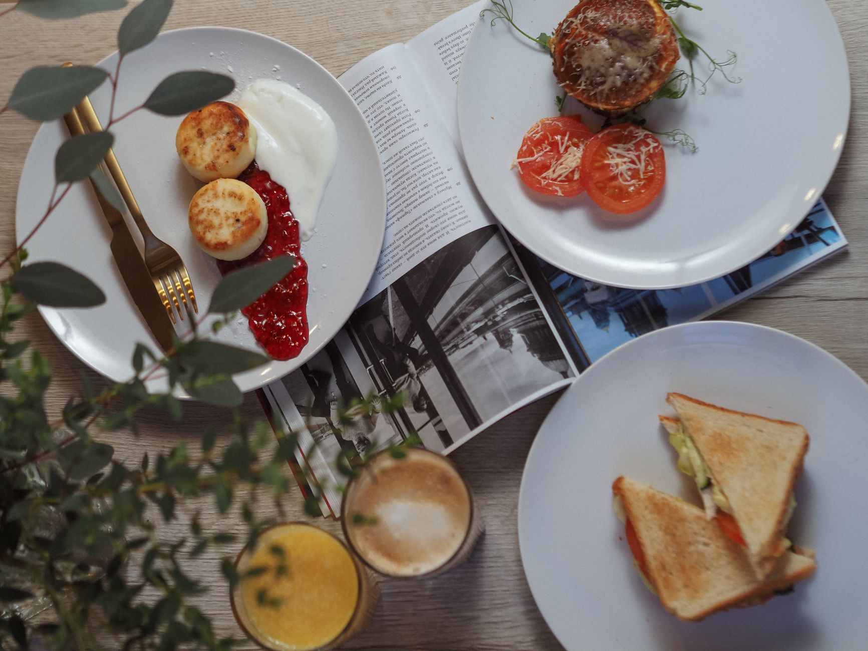 Breakfast plates, coffee and juice on a pale table