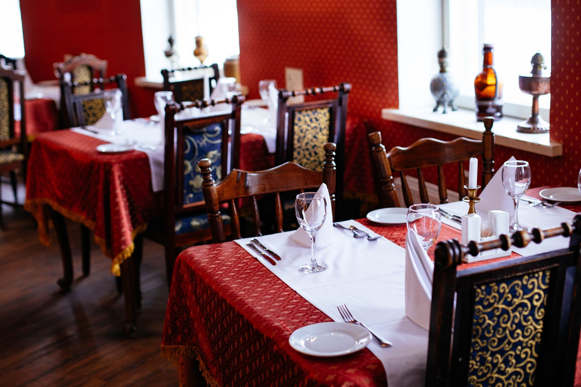 Set dining tables with linen, glassware and candles